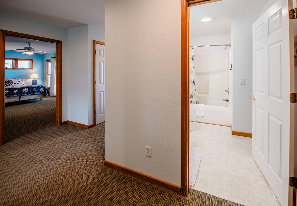 Hallway with a bathroom and the blue bedroom seen beyond