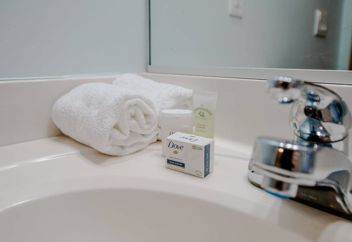 Folded white towel and soap on a bathroom counter
