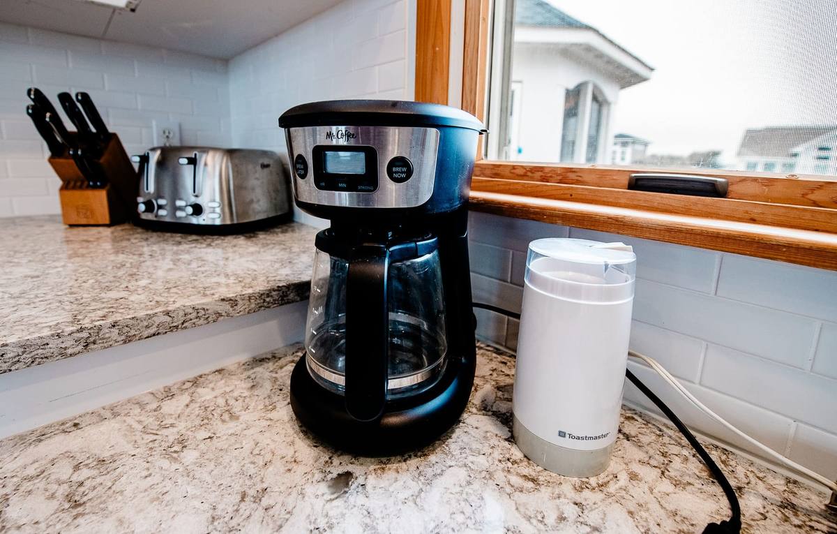 Drip coffee maker, grinder, and toaster on the granite counter