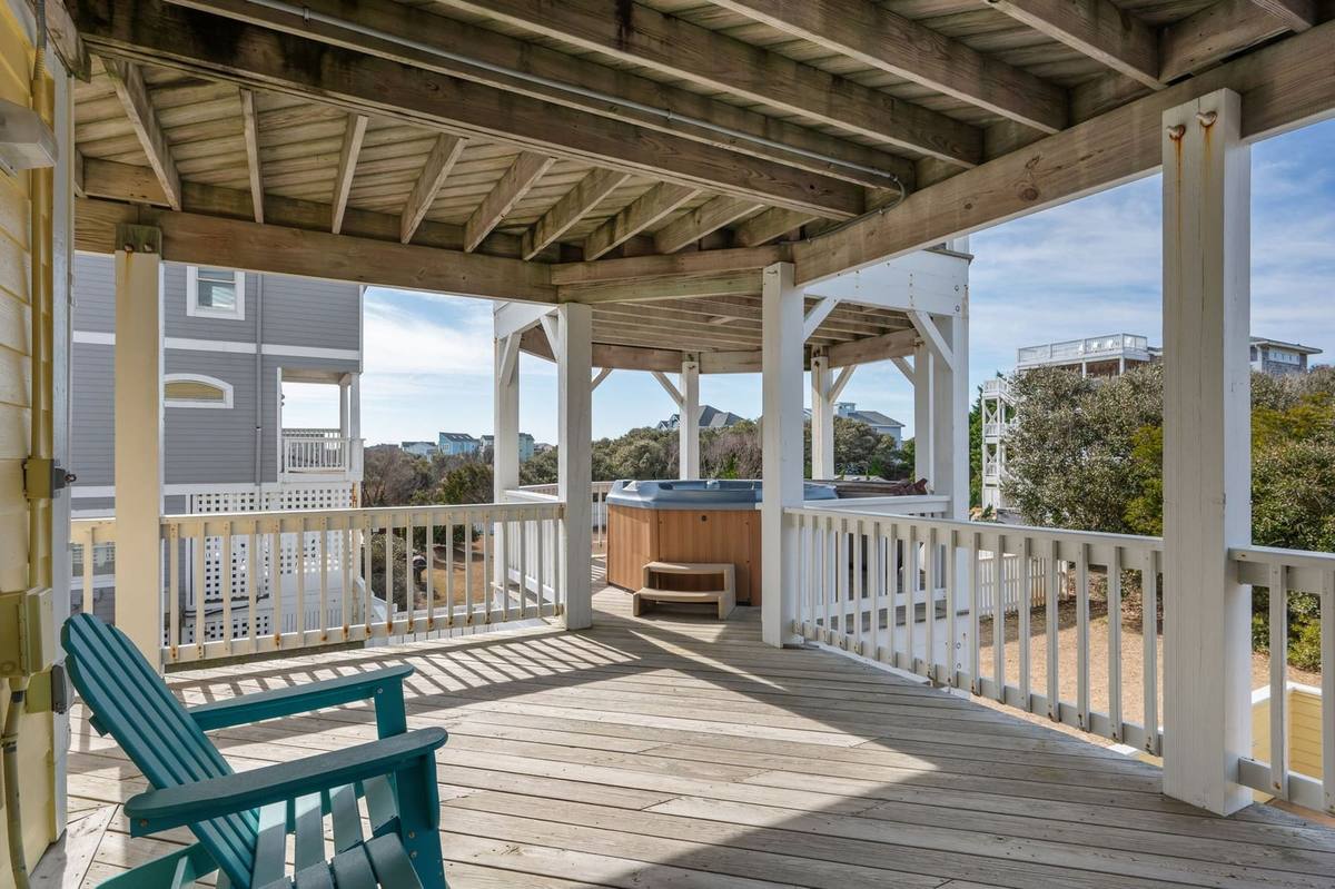 Covered rear deck on the mid level, positioned above the hot tub
