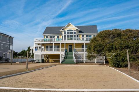 Front exterior of the six-bedroom house at 980 Lighthouse Drive, with covered parking and steps up to the entrance