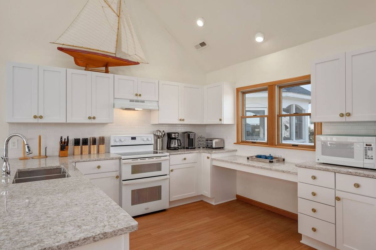 Top-level kitchen with white cabinetry, granite counters, and a built-in double wall oven