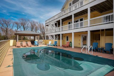 Private pool deck with lounge seating; the pool is shown with its winter safety cover on