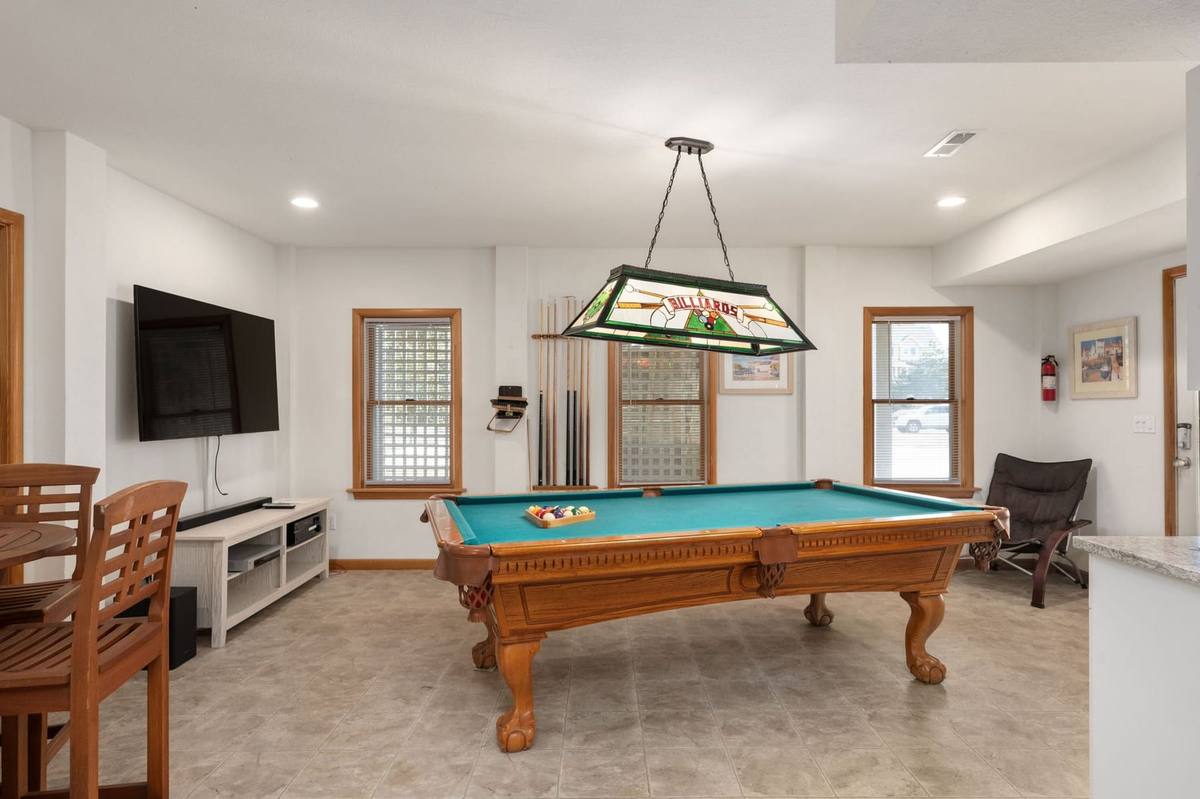 Bottom-level game room with a pool table and seating