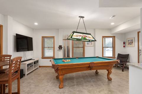 Bottom-level game room with a pool table and seating
