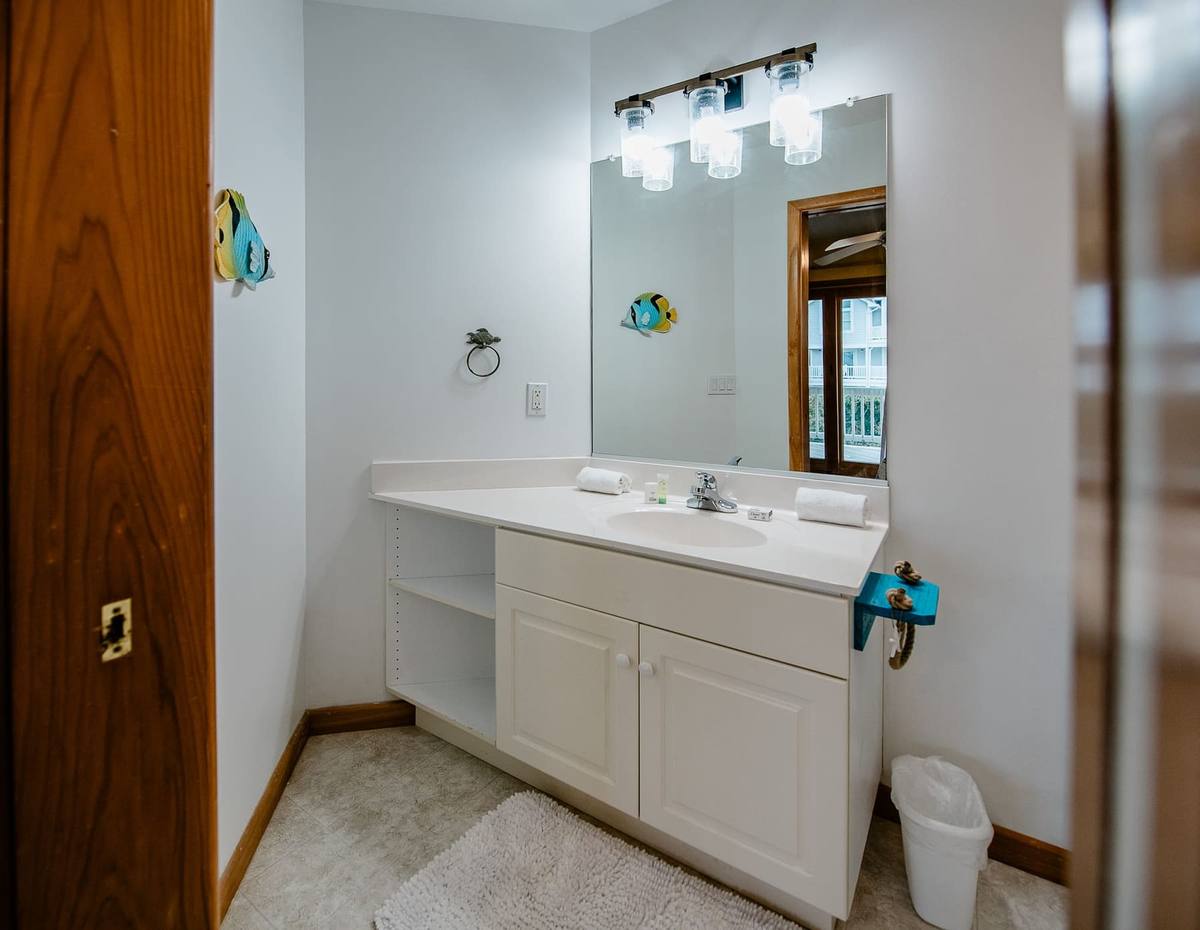 Bathroom vanity with a large mirror and a small tropical-fish decoration